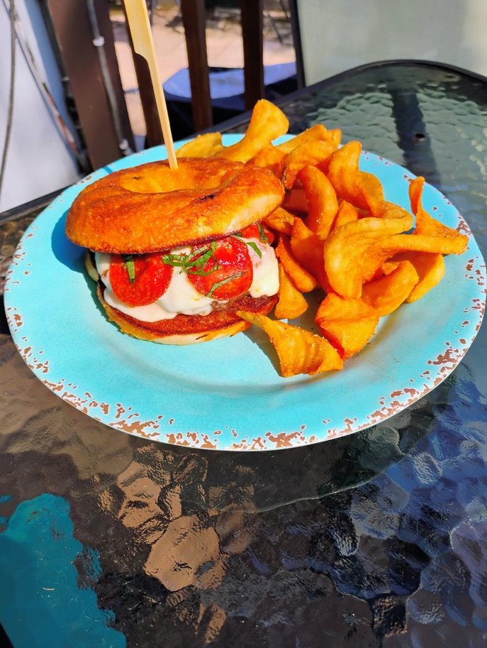 The Bear Essentials, July 2026 Burger of the Month, with mozzarella, pepperoni, basil, and marinara on a cheddar bagel