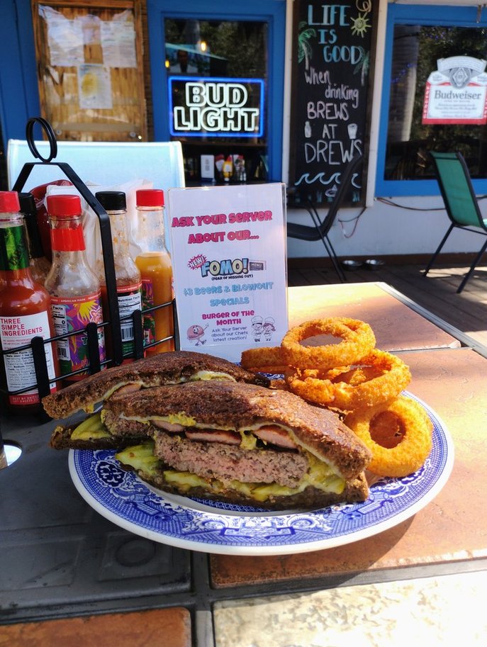 St. Patty's Day Melt, March 2026 Burger of the Month, with Swiss cheese, kielbasa, caramelized onions, and horseradish mustard on pumpernickel rye